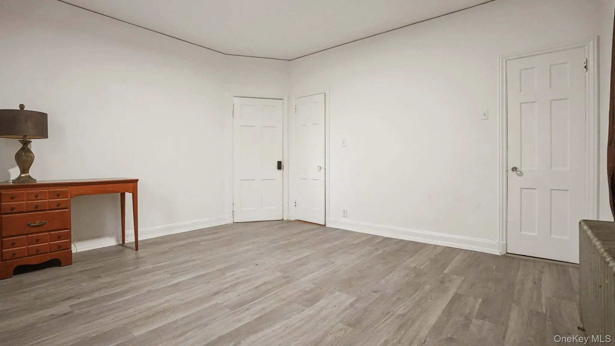 Unfurnished bedroom with light wood-style flooring and radiator heating unit Unfurnished bedroom with light wood-style flooring and radiator heating unit
