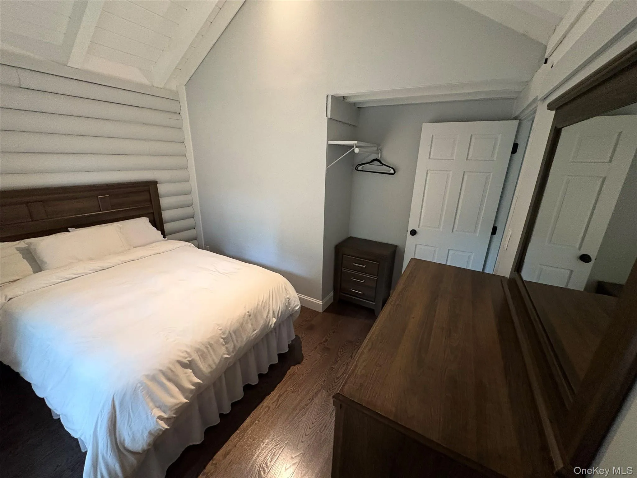 Bedroom with dark wood finished floors and baseboards Bedroom with dark wood finished floors and baseboards