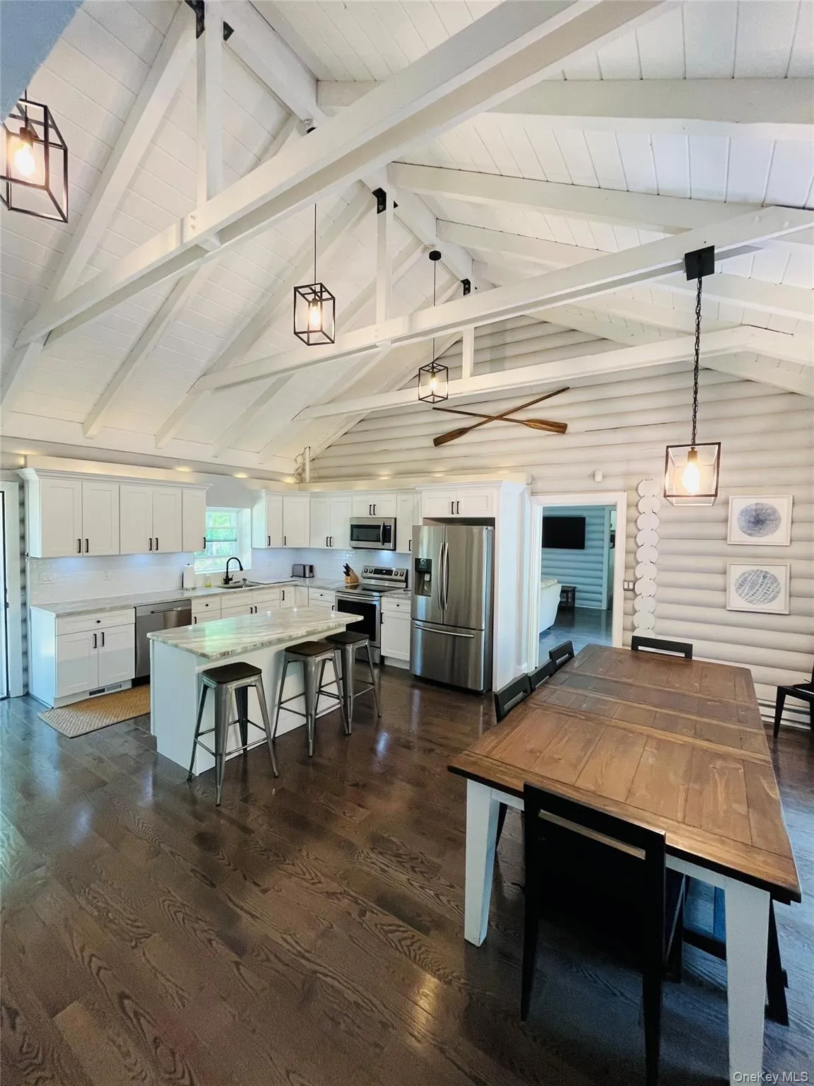 Dining room featuring dark wood-type flooring, beamed ceiling, and high vaulted ceiling Dining room featuring dark wood-type flooring, beamed ceiling, and high vaulted ceiling
