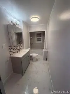 Full bath featuring vanity, tub / shower combination, ornamental molding, and light marble finish floors Full bath featuring vanity, tub / shower combination, ornamental molding, and light marble finish floors