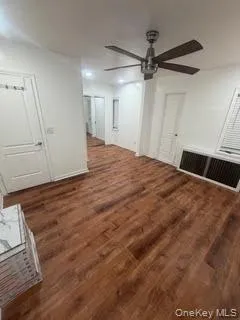 Unfurnished living room featuring dark wood-style flooring and ceiling fan Unfurnished living room featuring dark wood-style flooring and ceiling fan