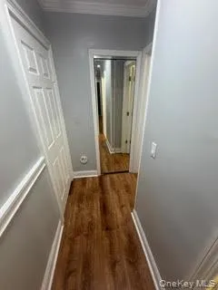 Corridor with dark wood finished floors and crown molding Corridor with dark wood finished floors and crown molding