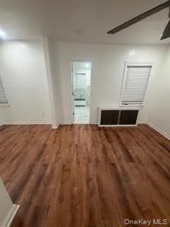 Spare room with ceiling fan and dark wood-type flooring Spare room with ceiling fan and dark wood-type flooring