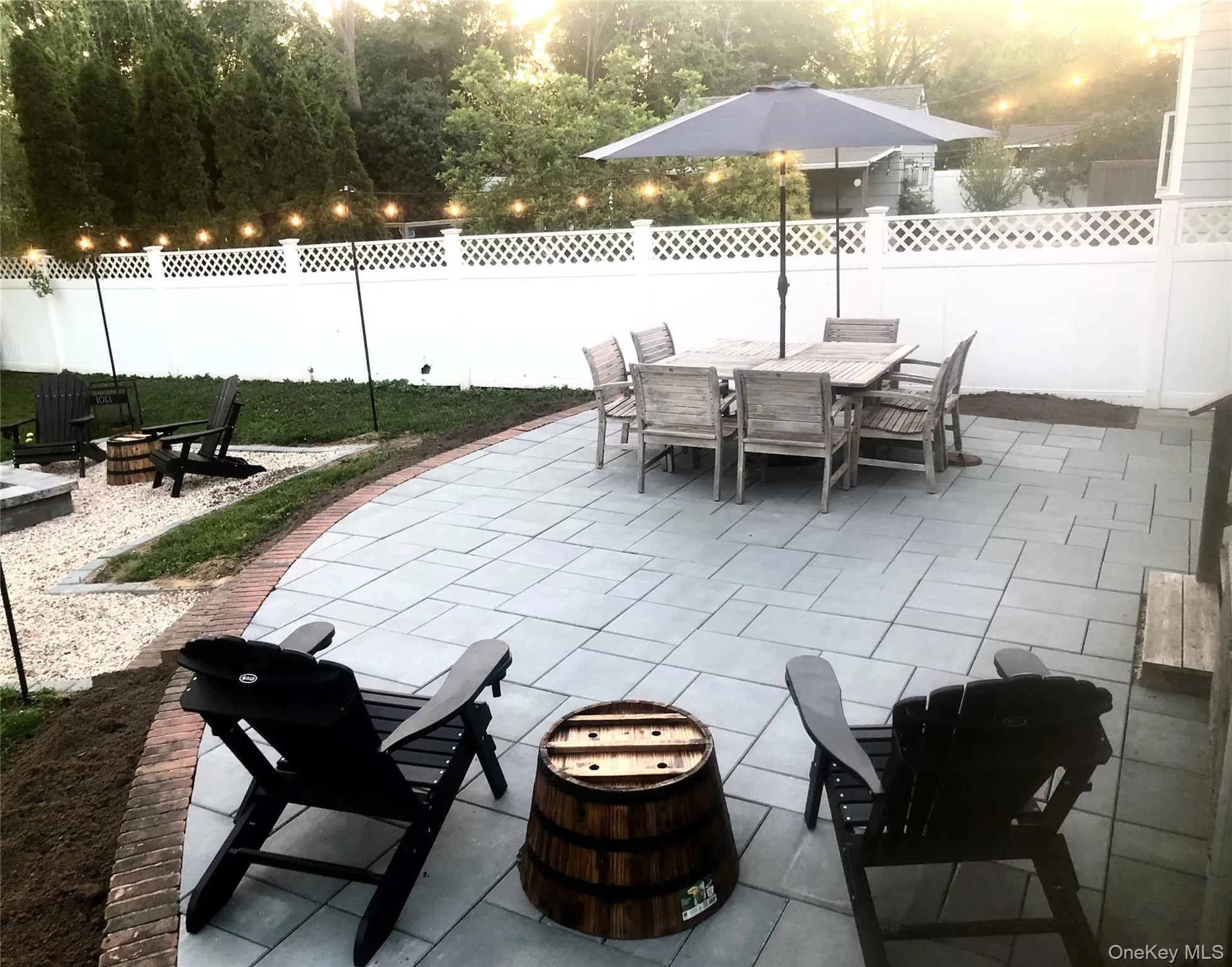 Fenced backyard featuring a fire pit, a patio, and outdoor dining area Fenced backyard featuring a fire pit, a patio, and outdoor dining area