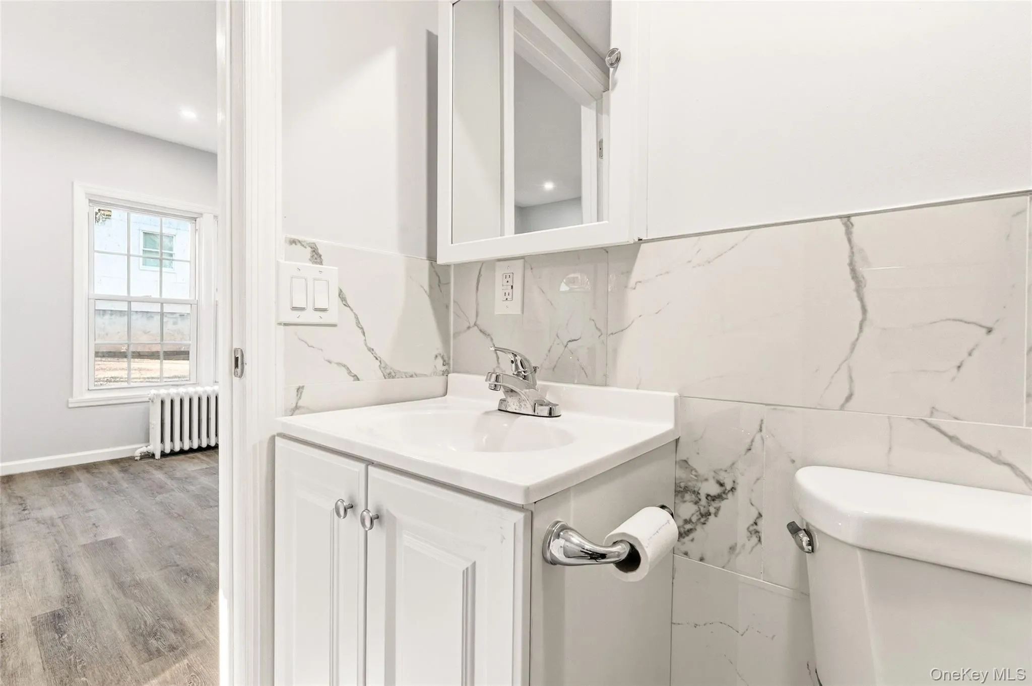 Half bathroom with vanity and radiator heating unit Half bathroom with vanity and radiator heating unit