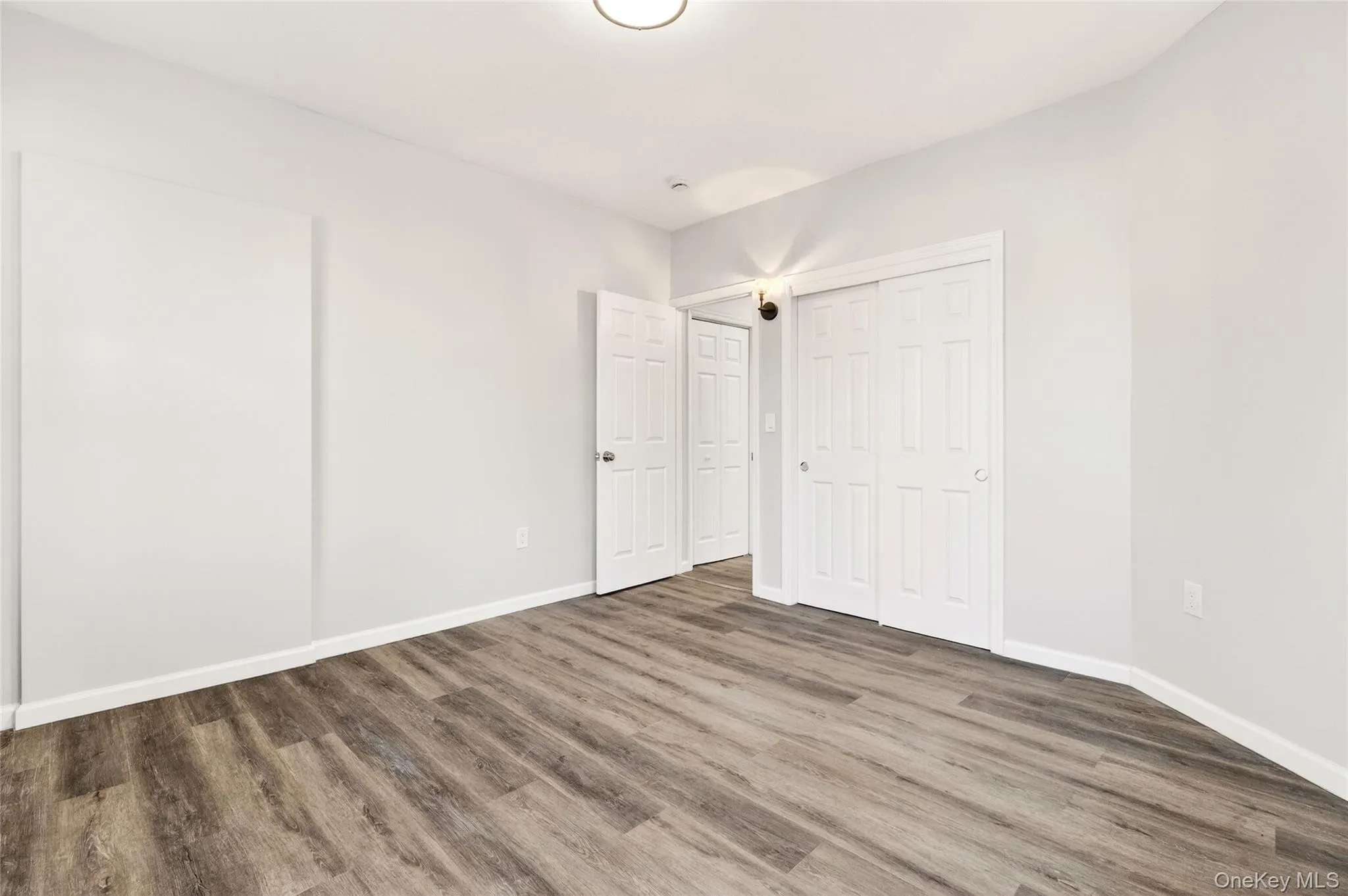 Unfurnished bedroom featuring wood finished floors and a closet Unfurnished bedroom featuring wood finished floors and a closet