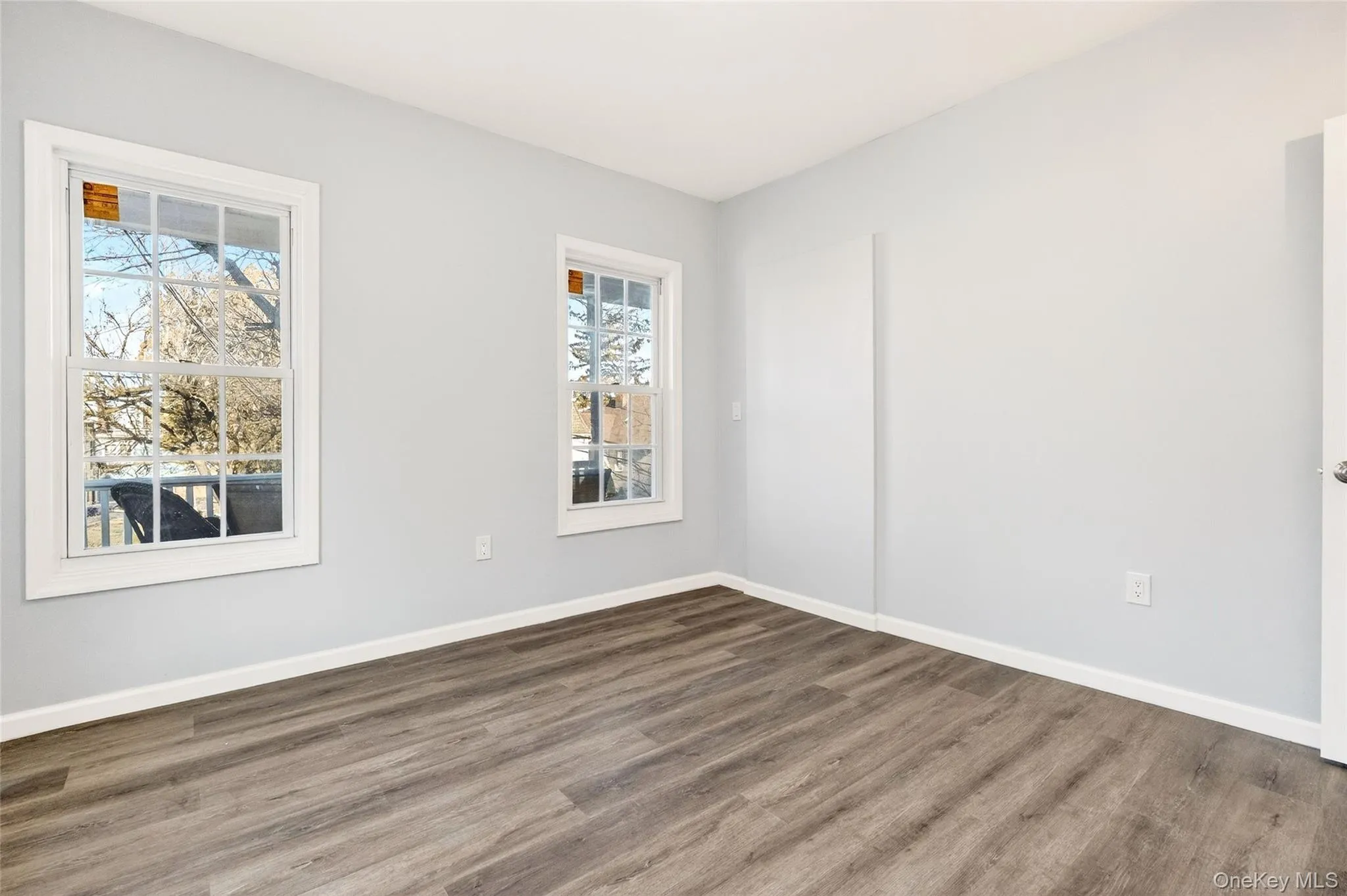 Empty room featuring wood finished floors and baseboards Empty room featuring wood finished floors and baseboards