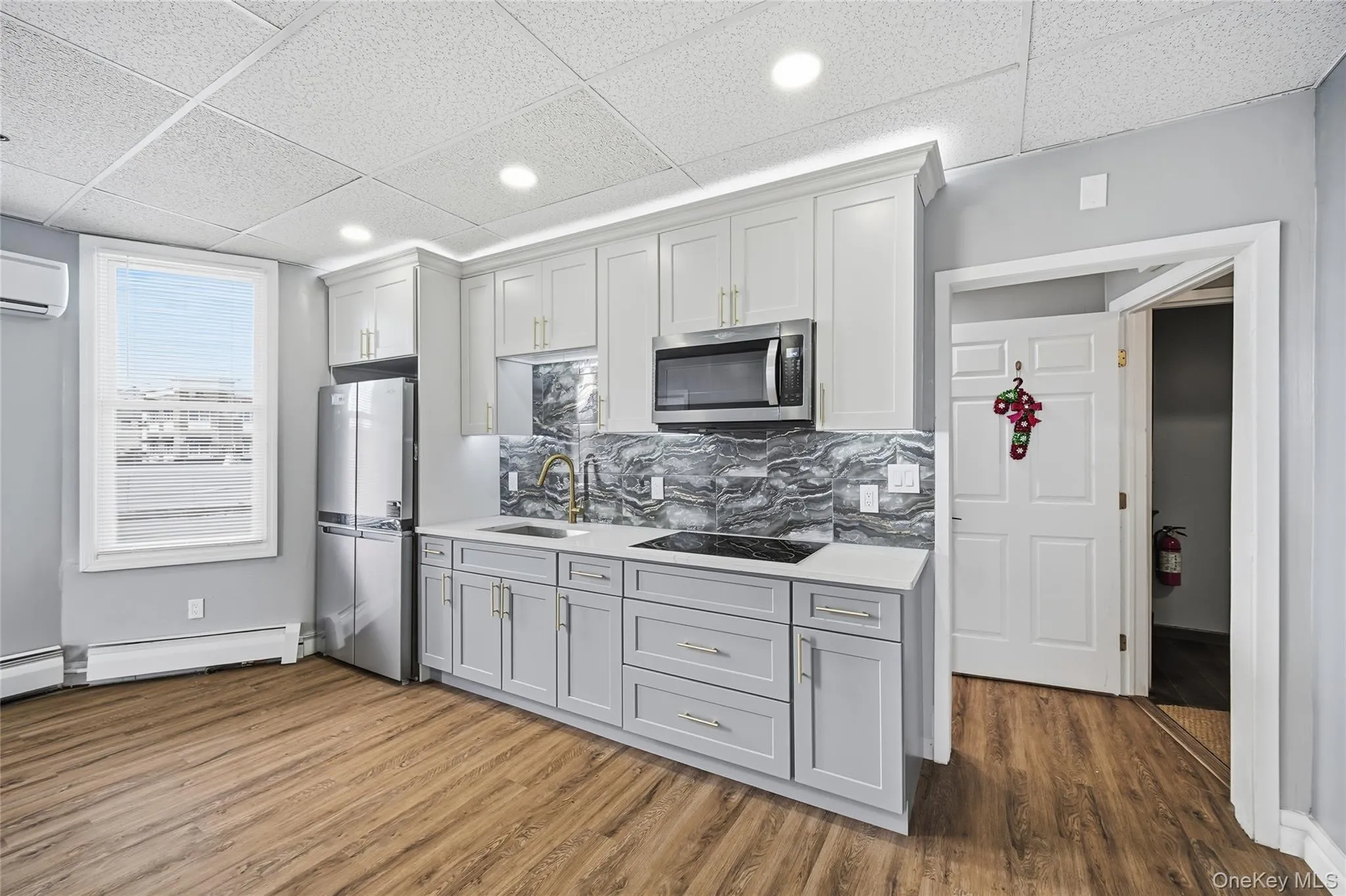 Kitchen featuring a paneled ceiling, appliances with stainless steel finishes, dark wood-type flooring, recessed lighting, and tasteful backsplash Kitchen featuring a paneled ceiling, appliances with stainless steel finishes, dark wood-type flooring, recessed lighting, and tasteful backsplash