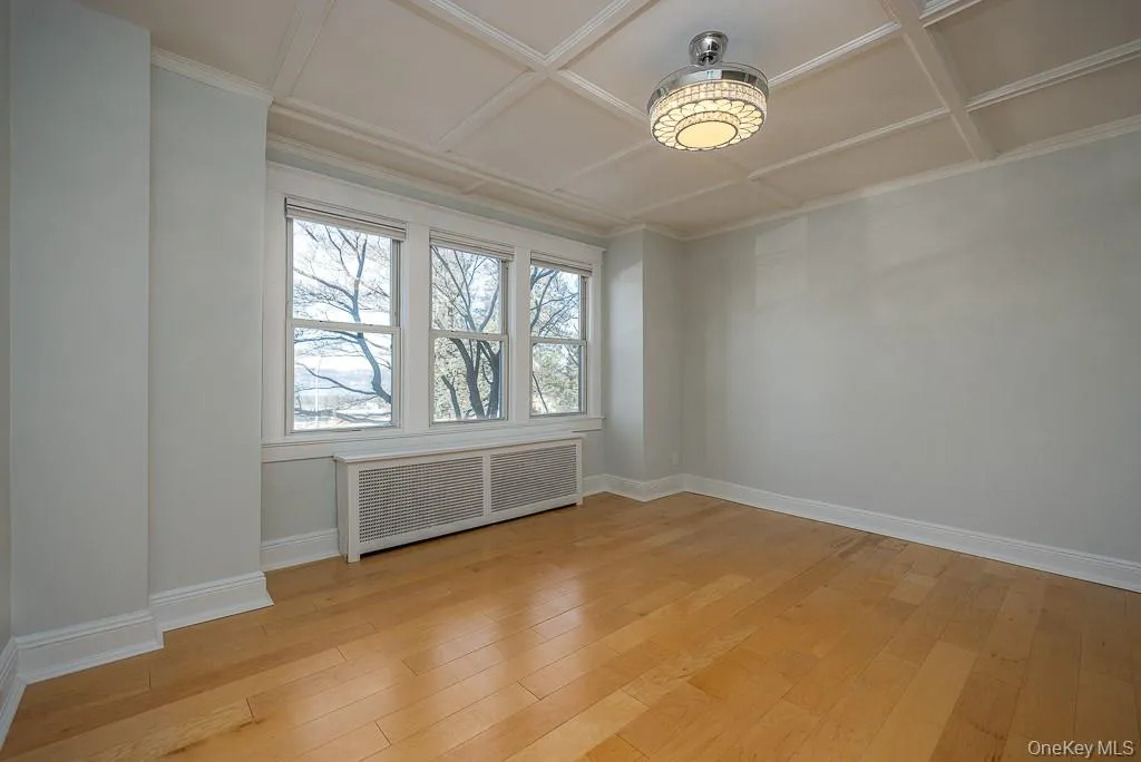 Empty room with radiator heating unit and light wood finished floors Empty room with radiator heating unit and light wood finished floors