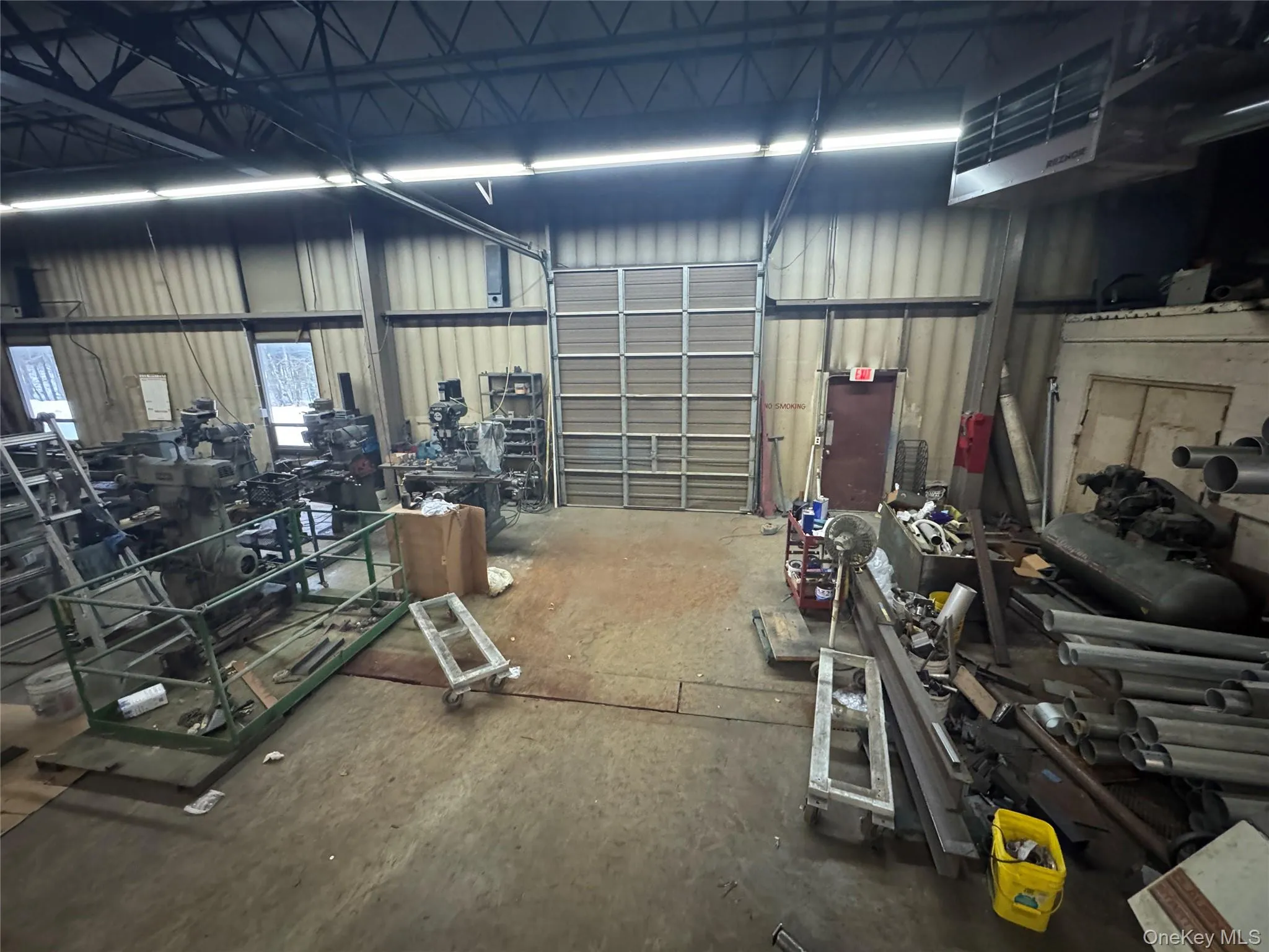 Garage with a heating unit, metal wall, and a workshop area Garage with a heating unit, metal wall, and a workshop area