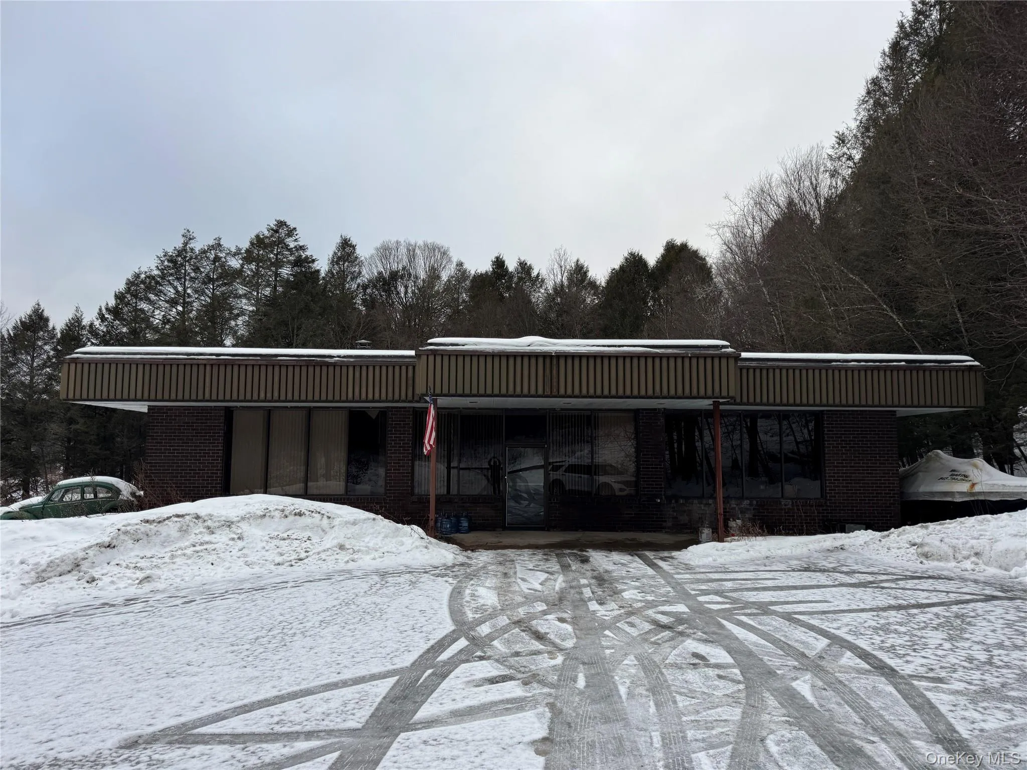 Snow covered building featuring a wooded view Snow covered building featuring a wooded view
