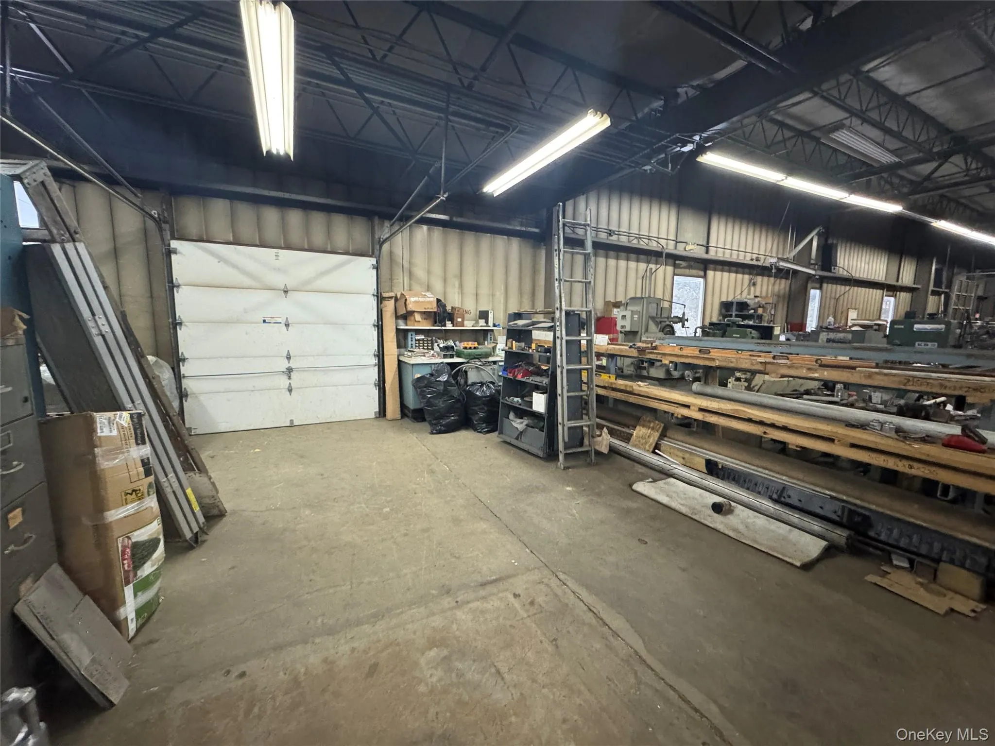 Garage with a workshop area and metal wall Garage with a workshop area and metal wall