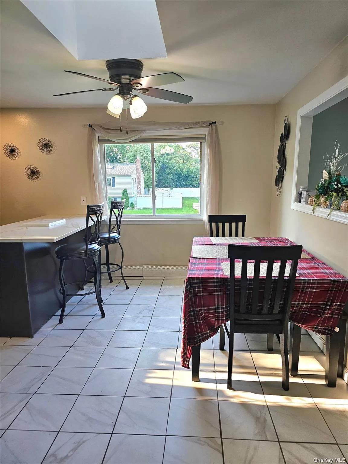 Dining area featuring light tile patterned floors and a ceiling fan Dining area featuring light tile patterned floors and a ceiling fan