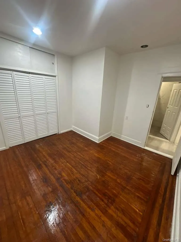 Spare room with dark wood-style flooring and recessed lighting Spare room with dark wood-style flooring and recessed lighting
