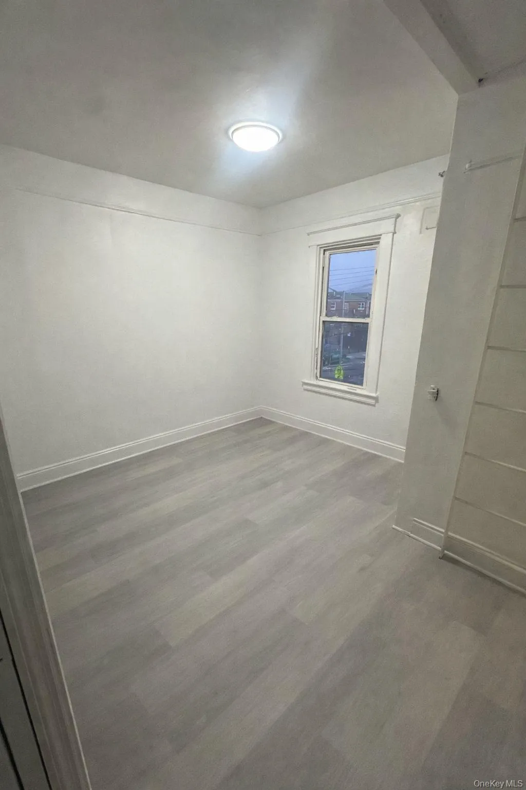 Unfurnished room with wood finished floors and baseboards Unfurnished room with wood finished floors and baseboards