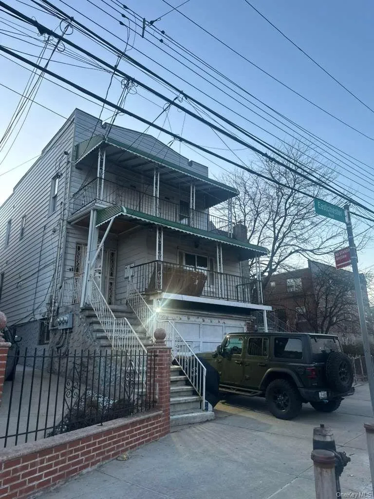 View of front of house with a balcony, stairway, concrete driveway, and covered porch View of front of house with a balcony, stairway, concrete driveway, and covered porch