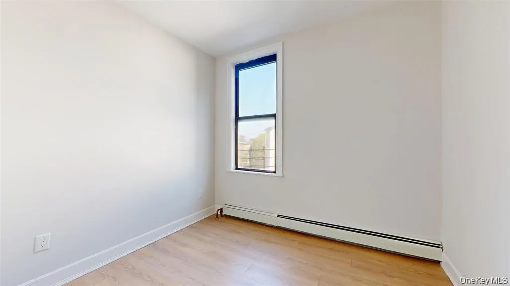 Empty room featuring baseboard heating and light wood-style flooring Empty room featuring baseboard heating and light wood-style flooring