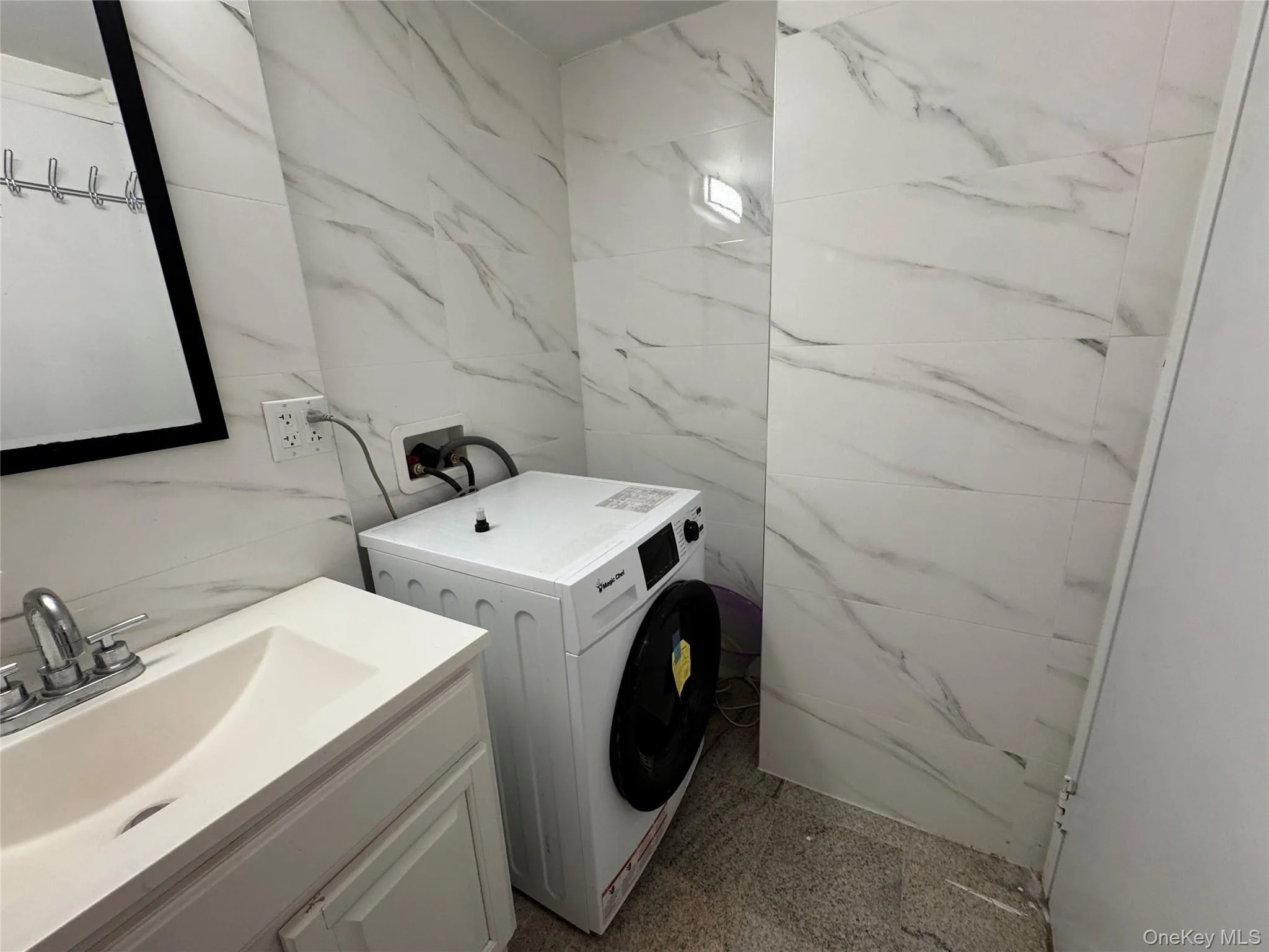 Washroom with washer / clothes dryer and tile walls Washroom with washer / clothes dryer and tile walls