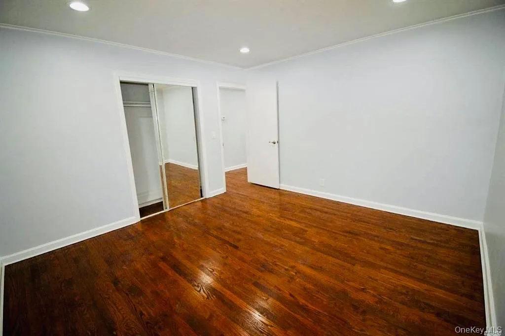Unfurnished bedroom with recessed lighting, a closet, dark wood finished floors, and crown molding Unfurnished bedroom with recessed lighting, a closet, dark wood finished floors, and crown molding