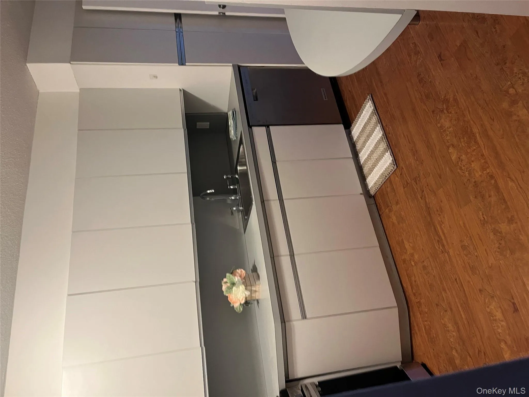 Kitchen with white cabinets, dark wood-style flooring, dishwashing machine, a textured ceiling, and stove Kitchen with white cabinets, dark wood-style flooring, dishwashing machine, a textured ceiling, and stove