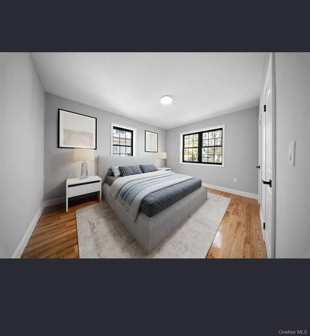 Bedroom featuring multiple windows and light wood-style flooring Bedroom featuring multiple windows and light wood-style flooring