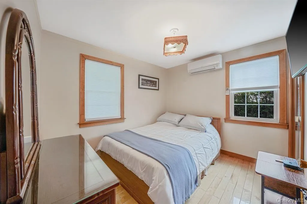 Bedroom featuring hardwood / wood-style flooring and a wall unit AC Bedroom featuring hardwood / wood-style flooring and a wall unit AC