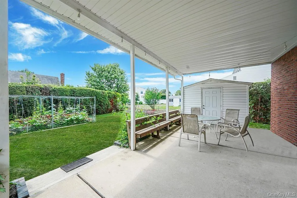 Fenced backyard with a garden, a patio, outdoor dining area, and a shed Fenced backyard with a garden, a patio, outdoor dining area, and a shed