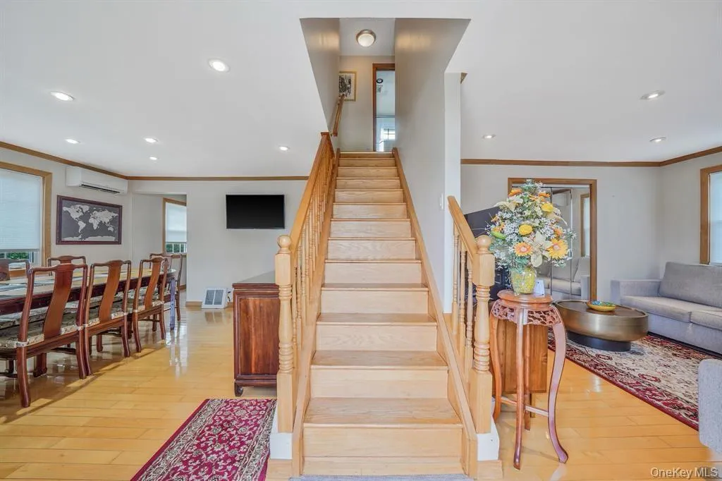 Stairway with recessed lighting, crown molding, hardwood / wood-style floors, plenty of natural light, and a wall mounted AC Stairway with recessed lighting, crown molding, hardwood / wood-style floors, plenty of natural light, and a wall mounted AC