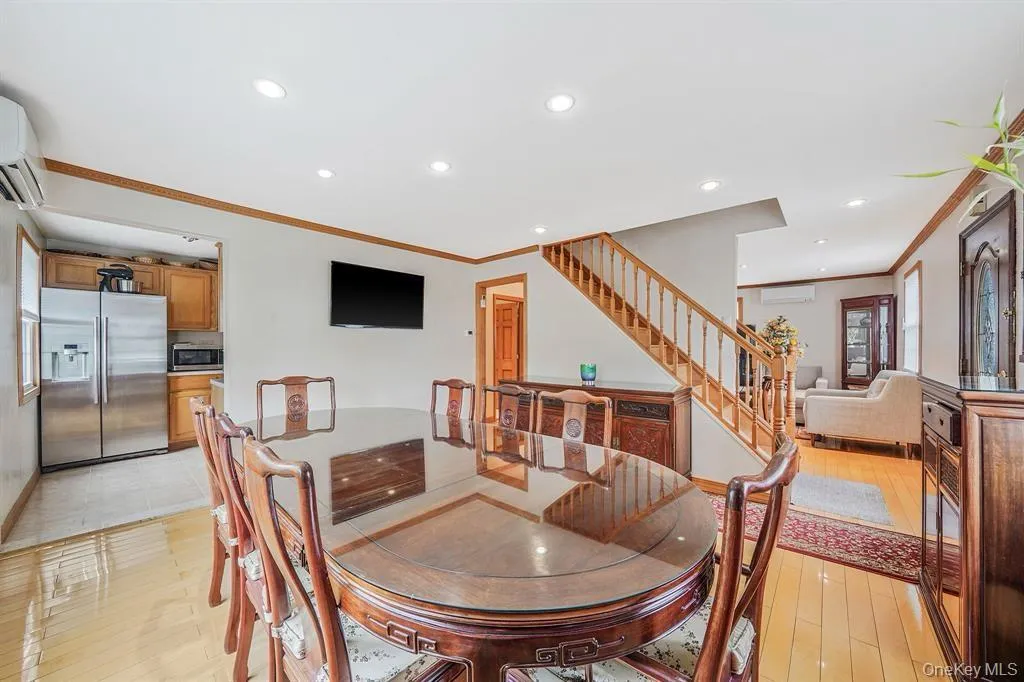Dining room with ornamental molding, recessed lighting, stairway, a wall mounted AC, and light wood-style floors Dining room with ornamental molding, recessed lighting, stairway, a wall mounted AC, and light wood-style floors