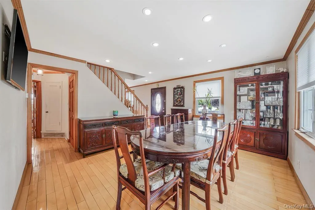 Dining space with ornamental molding, light wood finished floors, recessed lighting, and stairway Dining space with ornamental molding, light wood finished floors, recessed lighting, and stairway