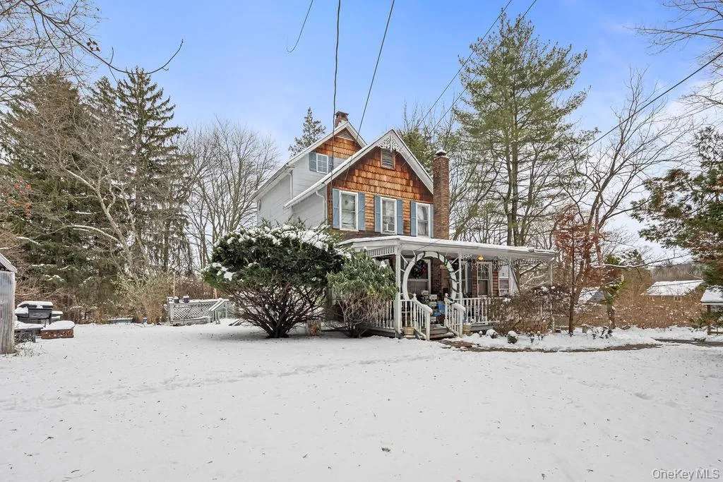 View of front facade featuring a porch and a chimney View of front facade featuring a porch and a chimney