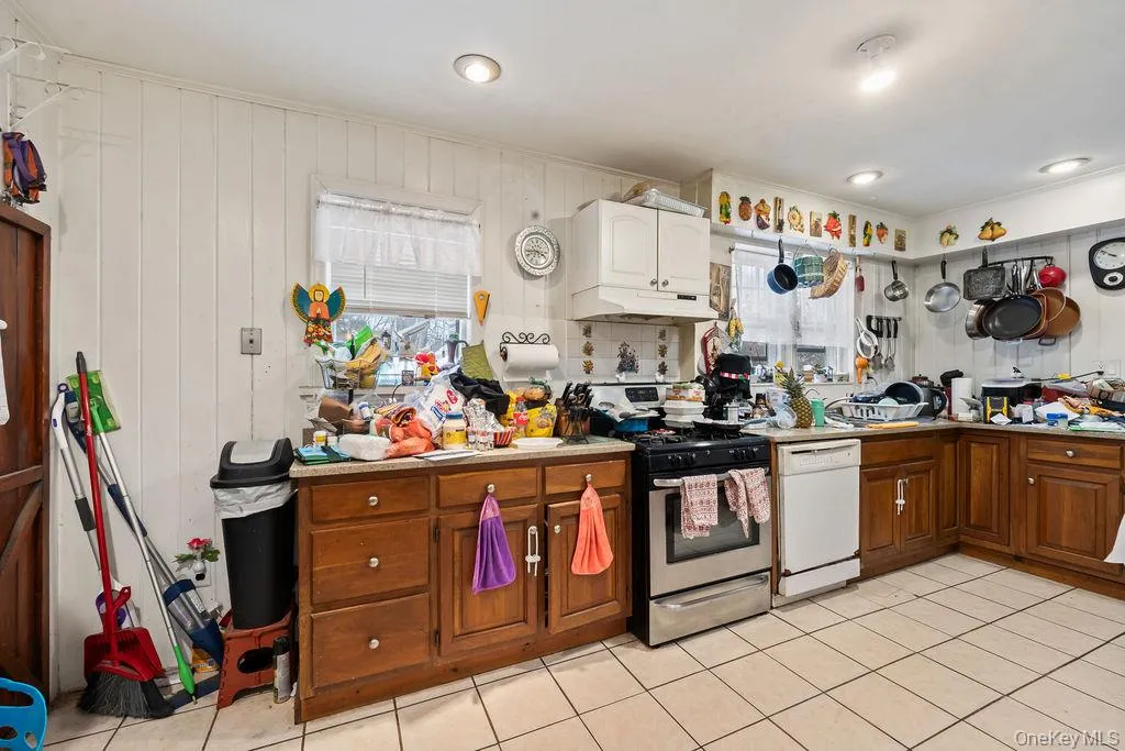 Kitchen featuring stainless steel gas range, white dishwasher, light countertops, and healthy amount of natural light Kitchen featuring stainless steel gas range, white dishwasher, light countertops, and healthy amount of natural light