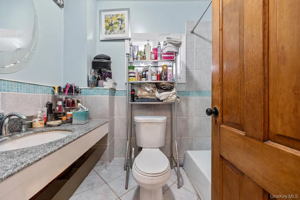 Full bath with tile walls, vanity, and shower / bath combo Full bath with tile walls, vanity, and shower / bath combo