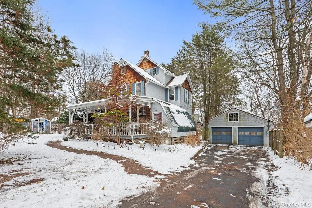View of front of house featuring an outbuilding, a chimney, a detached garage, and a deck View of front of house featuring an outbuilding, a chimney, a detached garage, and a deck