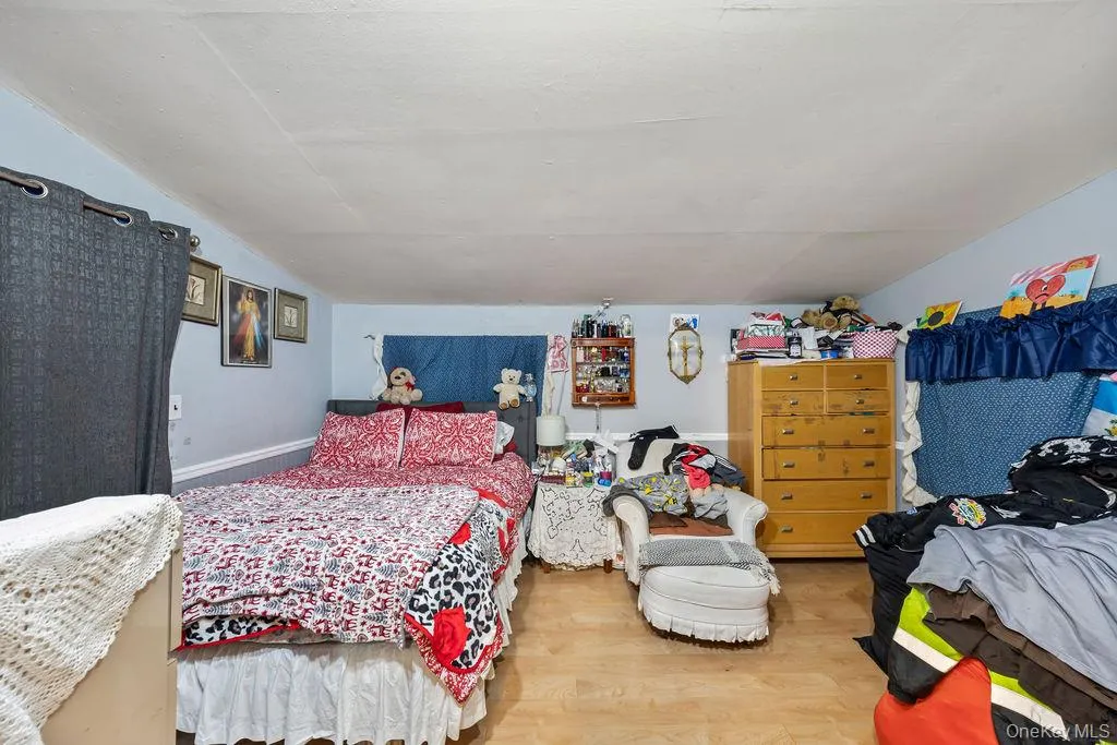 Bedroom with vaulted ceiling and wood finished floors Bedroom with vaulted ceiling and wood finished floors