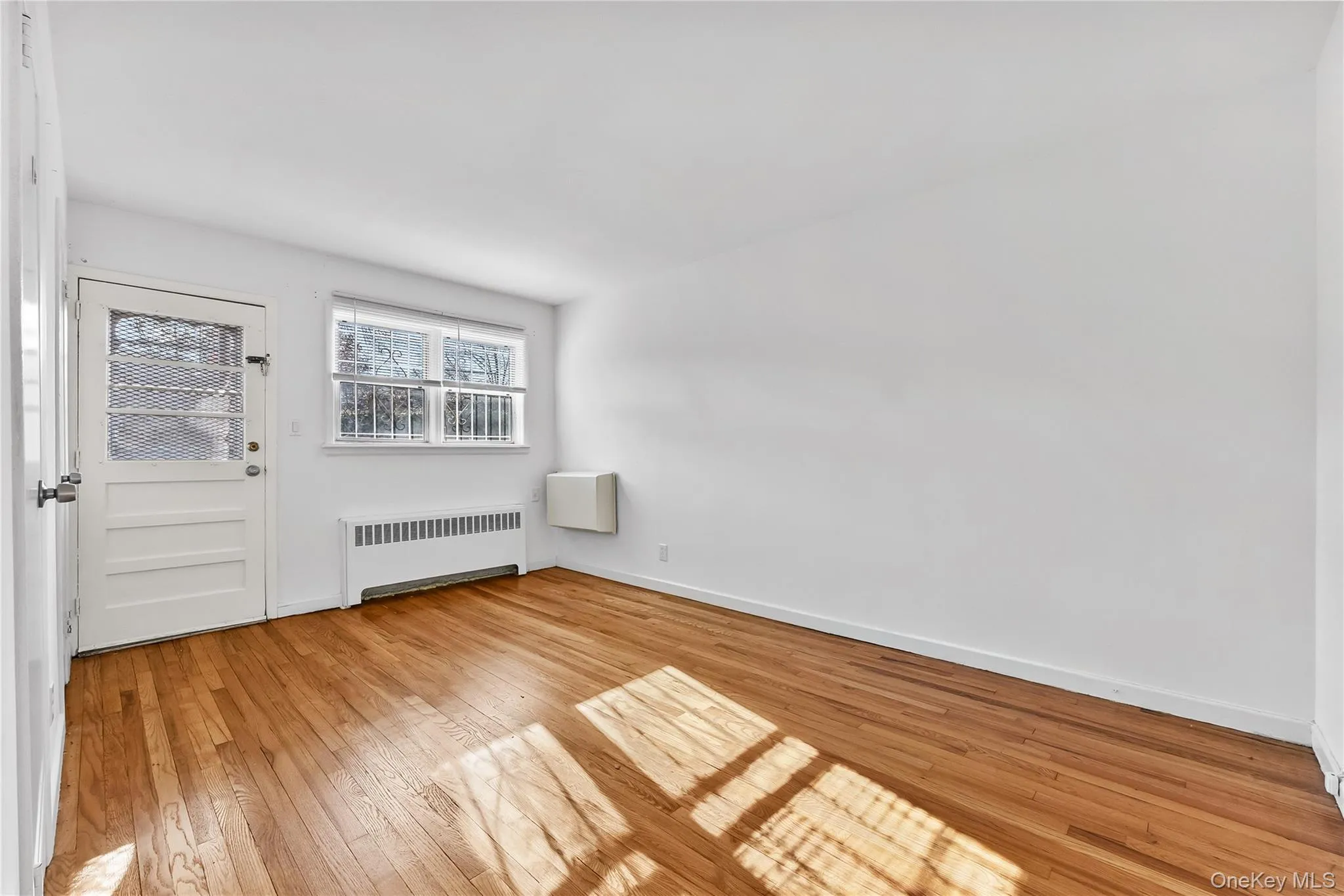 Foyer featuring radiator and light wood-type flooring Foyer featuring radiator and light wood-type flooring