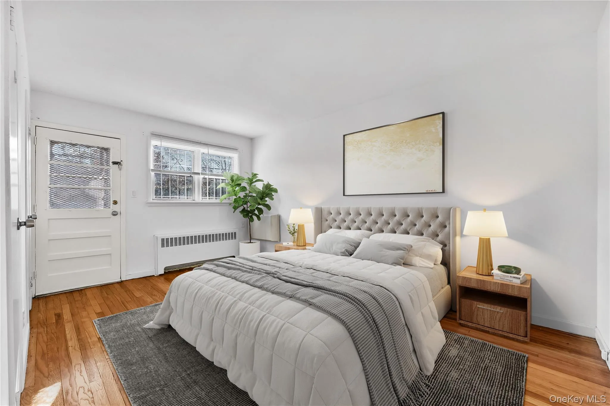 Bedroom with radiator heating unit and light wood-type flooring Bedroom with radiator heating unit and light wood-type flooring