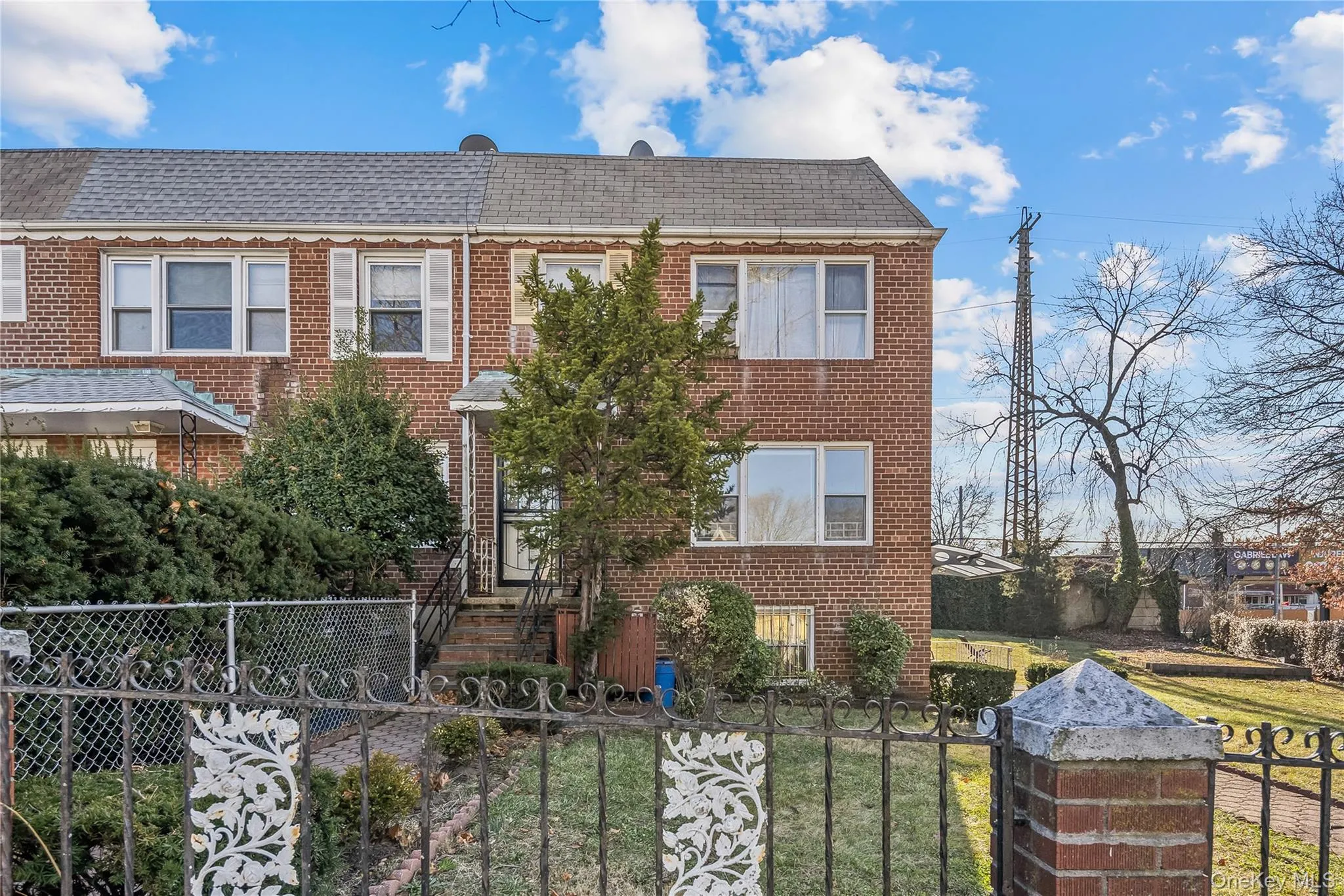 View of front facade with a fenced front yard, brick siding, and roof with shingles View of front facade with a fenced front yard, brick siding, and roof with shingles