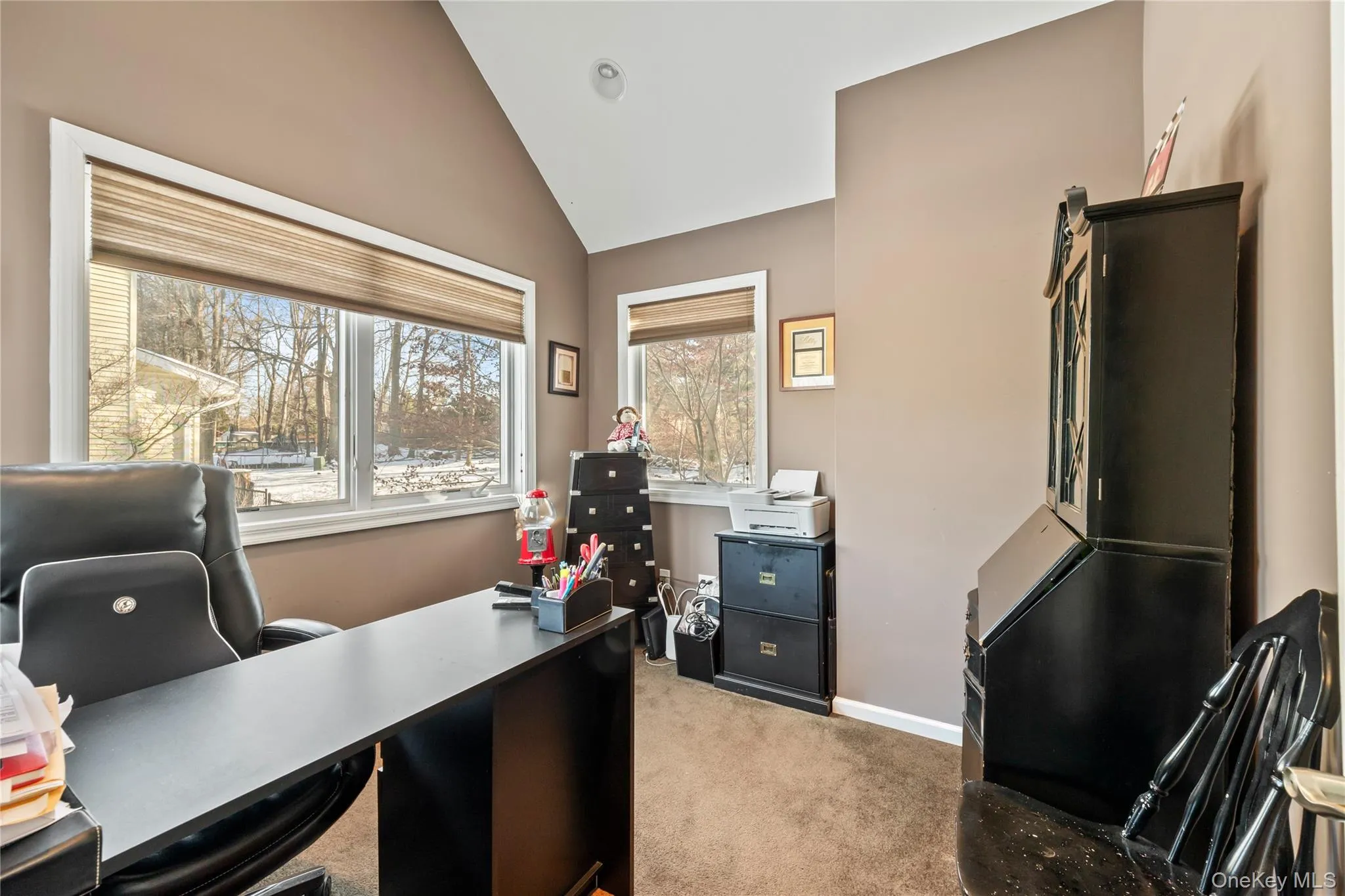 Home office with lofted ceiling and light carpet Home office with lofted ceiling and light carpet