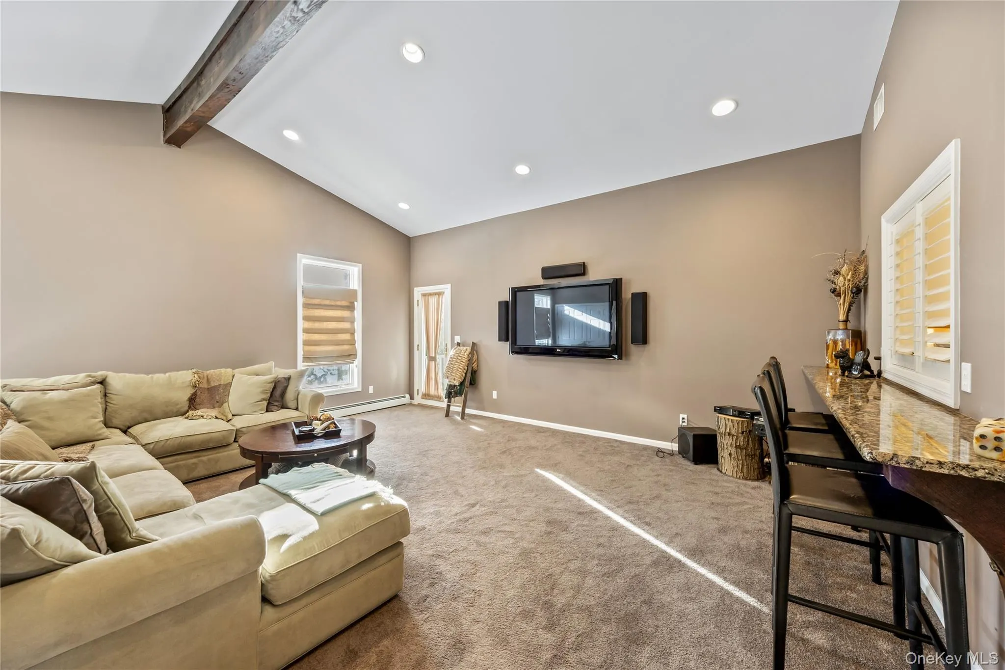 Carpeted living area featuring a baseboard heating unit and recessed lighting Carpeted living area featuring a baseboard heating unit and recessed lighting