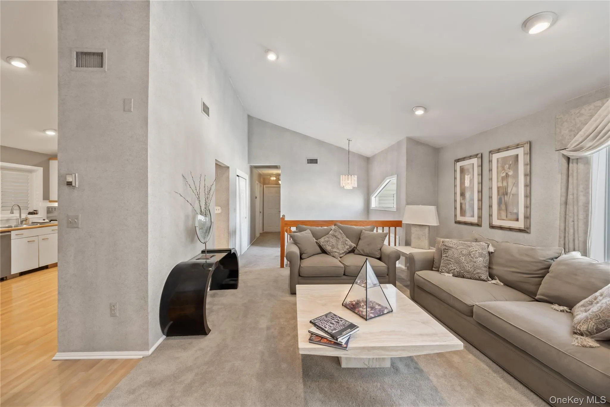 Living room with light wood-type flooring, high vaulted ceiling, and recessed lighting Living room with light wood-type flooring, high vaulted ceiling, and recessed lighting