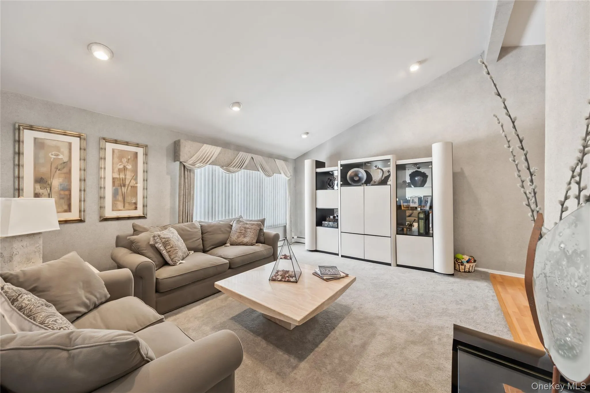 Living room with carpet flooring and high vaulted ceiling Living room with carpet flooring and high vaulted ceiling