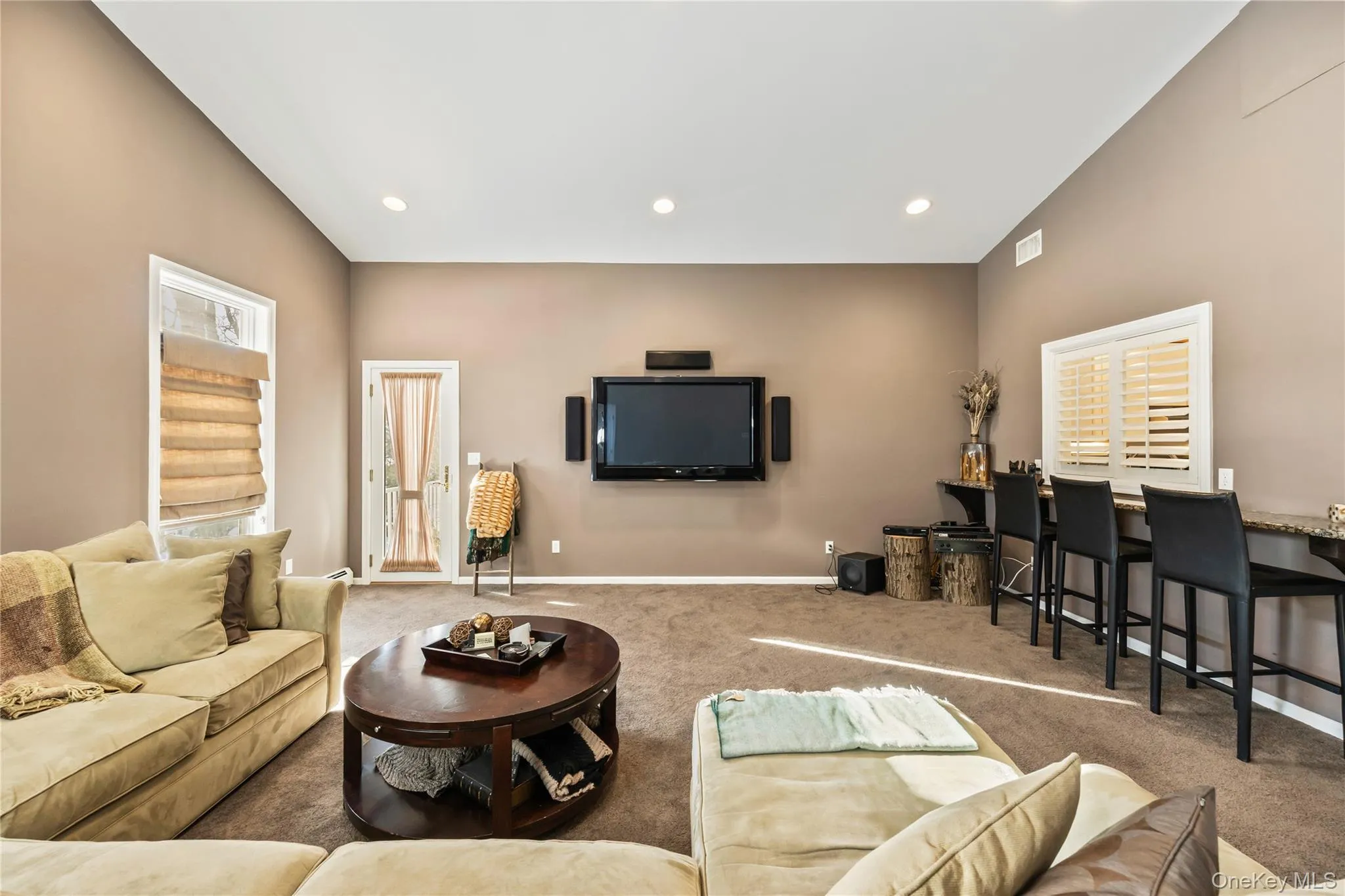 Living area featuring carpet floors, high vaulted ceiling, and recessed lighting Living area featuring carpet floors, high vaulted ceiling, and recessed lighting