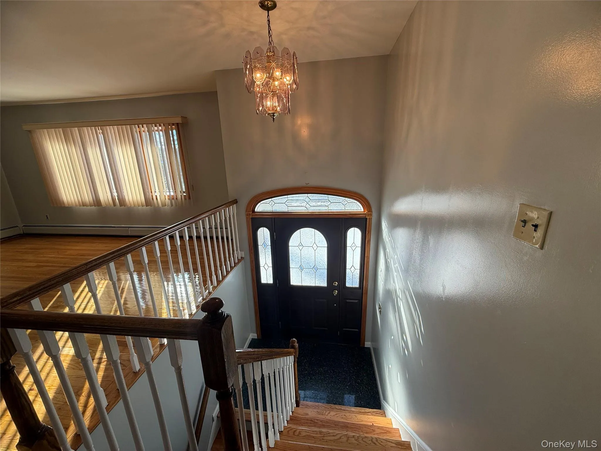 Entrance foyer with wood finished floors and a chandelier Entrance foyer with wood finished floors and a chandelier