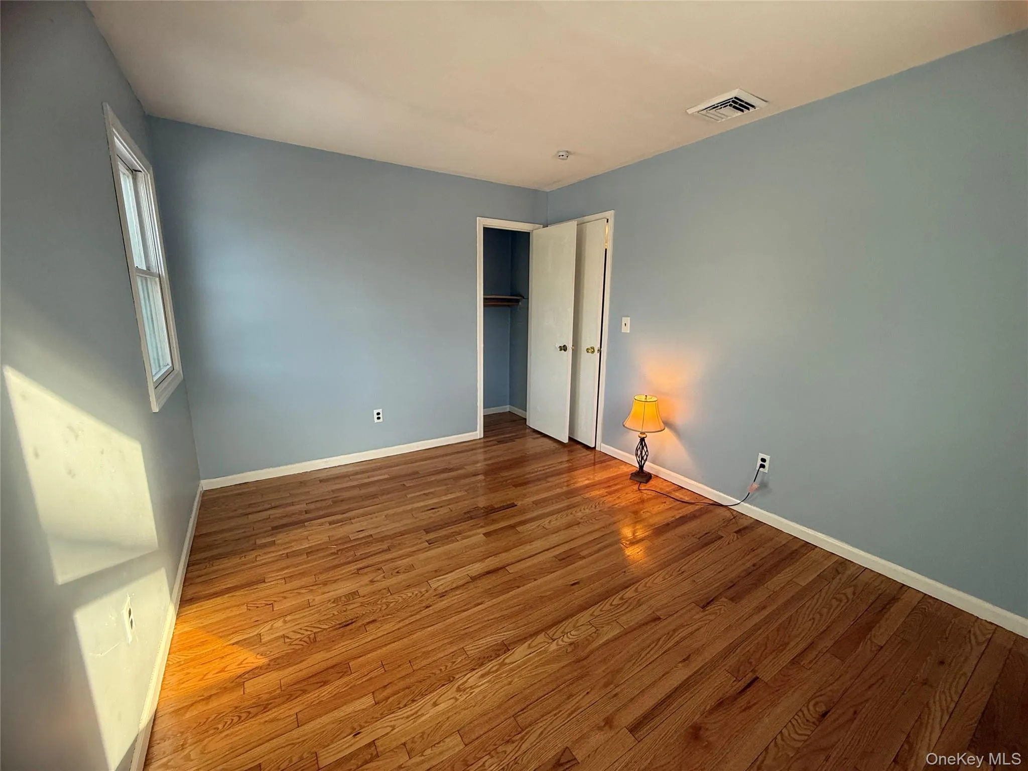 Unfurnished bedroom with wood finished floors and a closet Unfurnished bedroom with wood finished floors and a closet