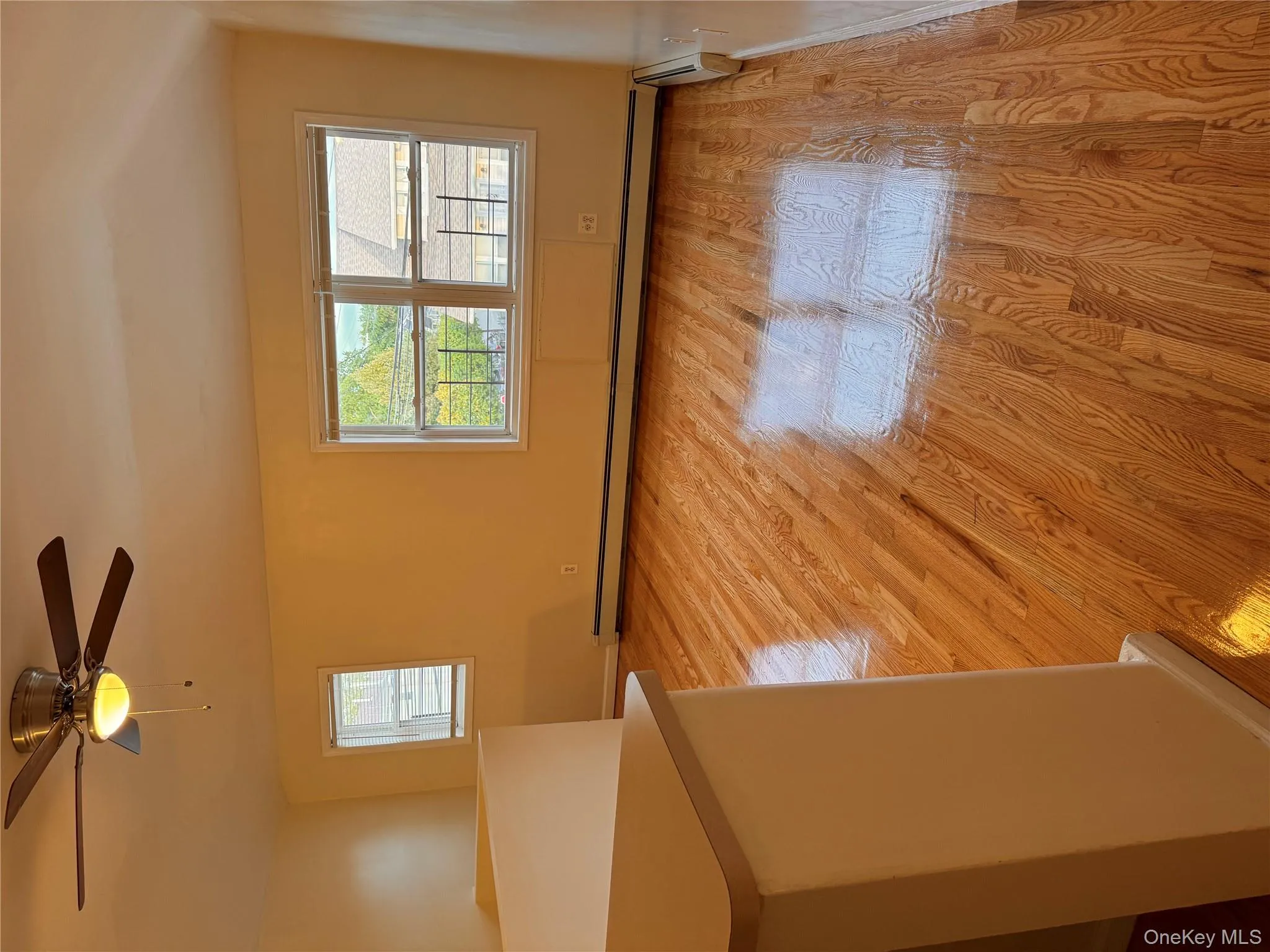 Empty room with healthy amount of natural light, light wood-type flooring, baseboard heating, and ceiling fan Empty room with healthy amount of natural light, light wood-type flooring, baseboard heating, and ceiling fan