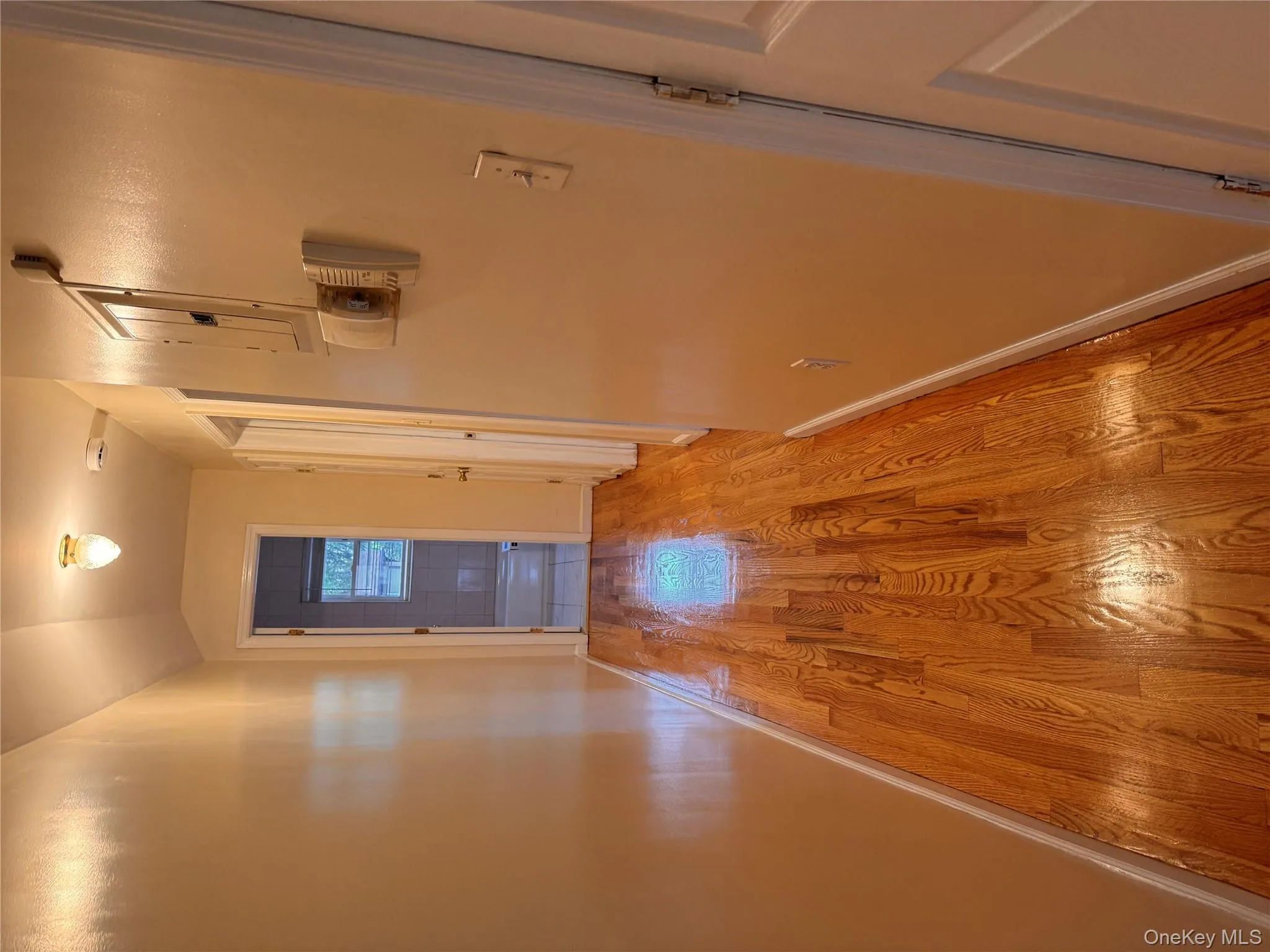 Corridor with wood finished floors, lofted ceiling, and electric panel Corridor with wood finished floors, lofted ceiling, and electric panel