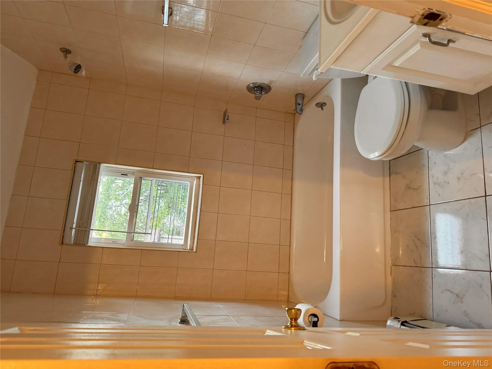 Full bath featuring vanity, shower combination, and light marble finish floors Full bath featuring vanity, shower combination, and light marble finish floors