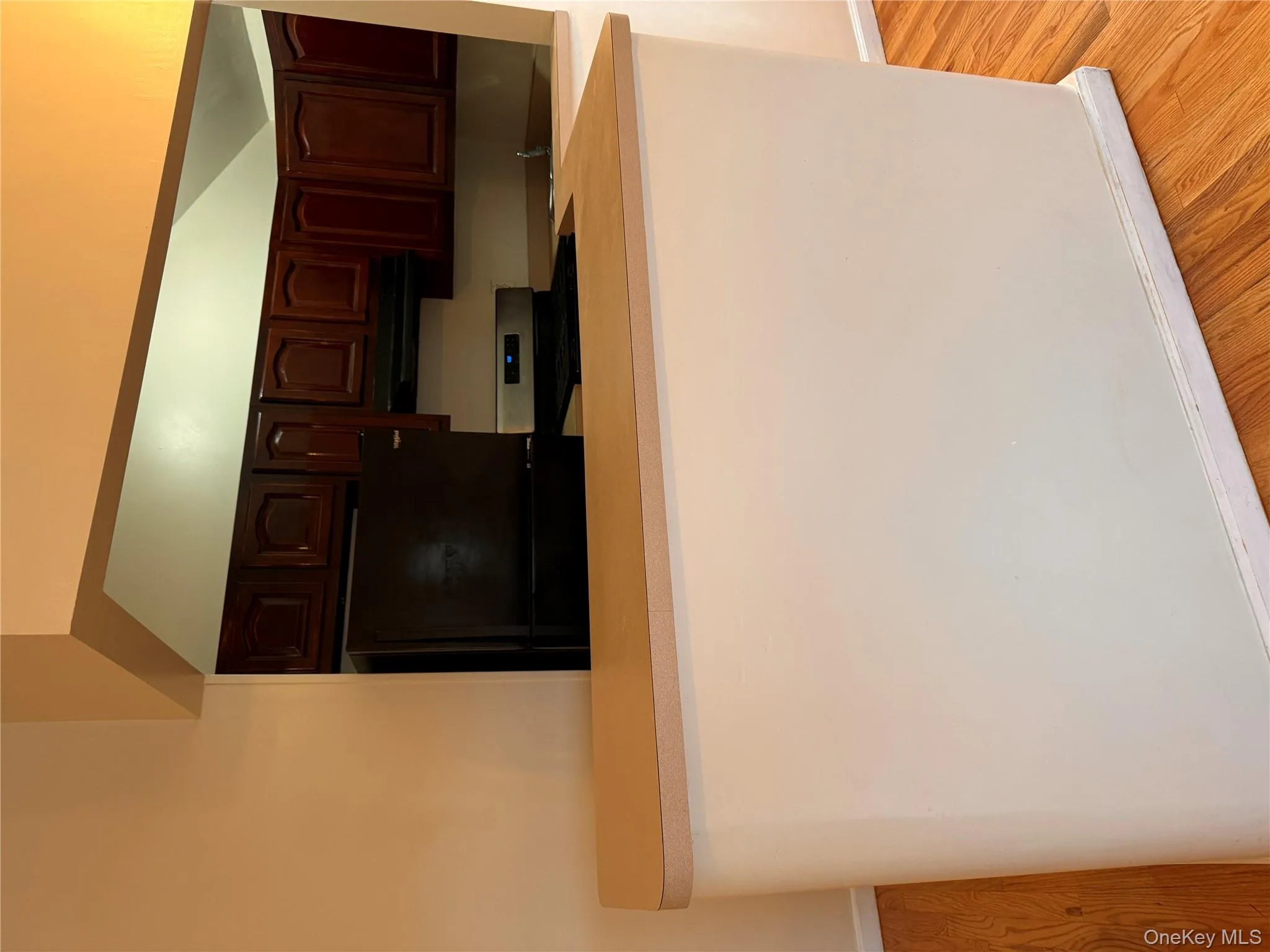 Kitchen featuring light wood-style flooring, stainless steel fridge, white range, and light countertops Kitchen featuring light wood-style flooring, stainless steel fridge, white range, and light countertops