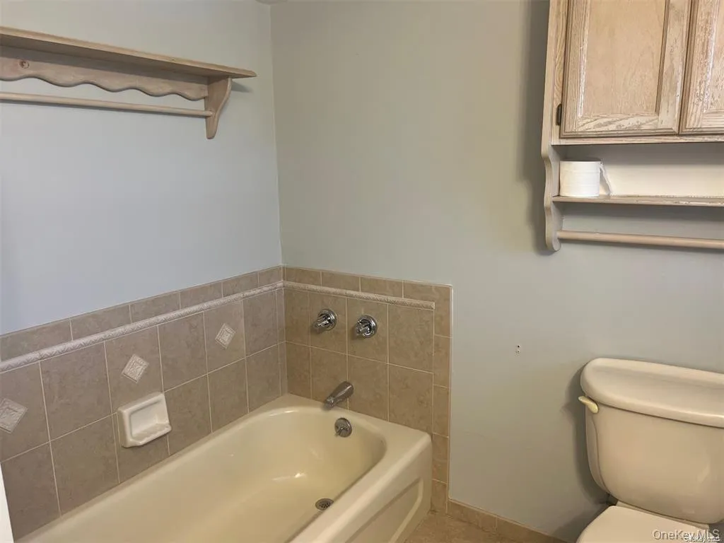 Bathroom with a bath and baseboards Bathroom with a bath and baseboards